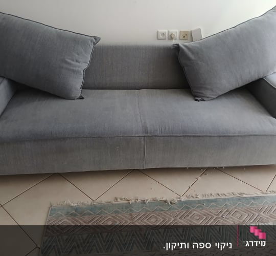 ספה אפורה עם כריות על רצפת אריחים